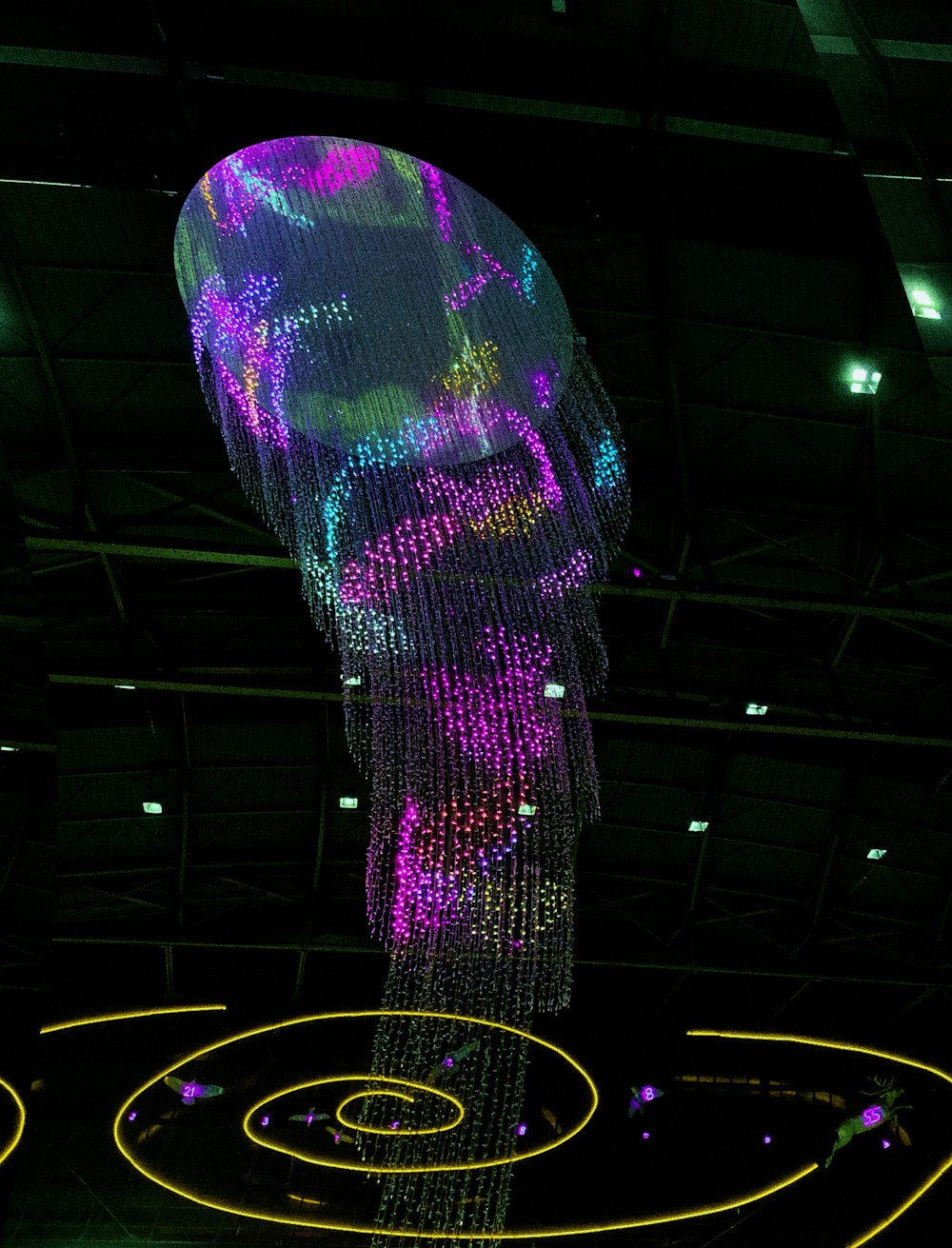 Une grande sculpture de méduse est illuminée dans l’obscurité