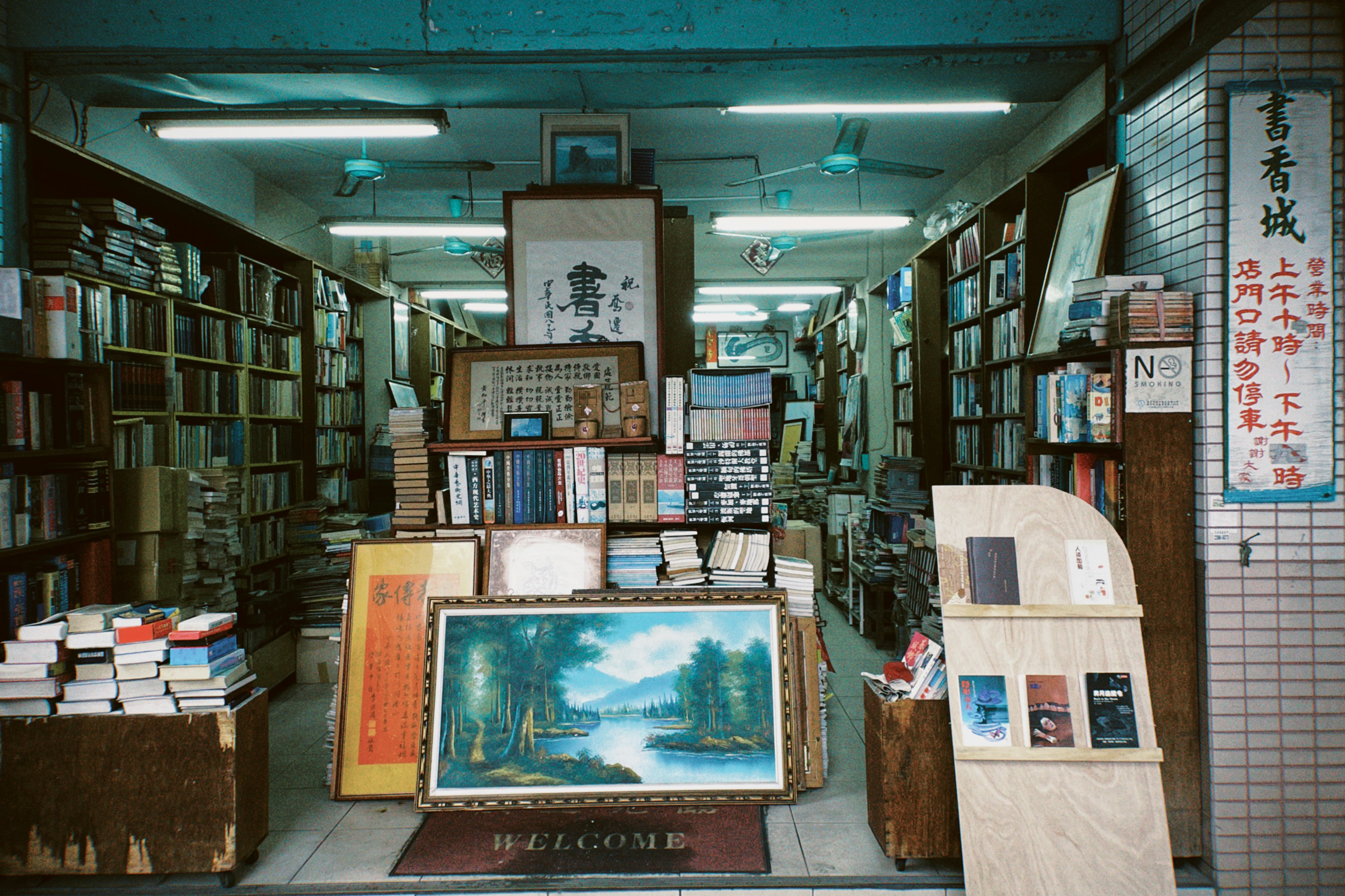 a room filled with lots of books and paintings, 