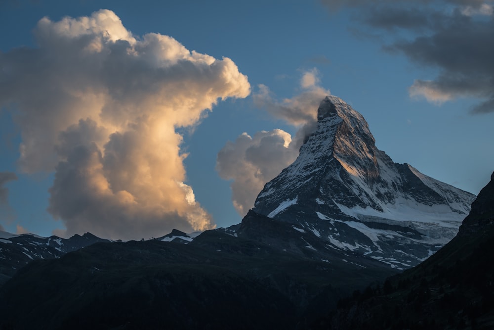 a snow covered mountain under a cloudy sky