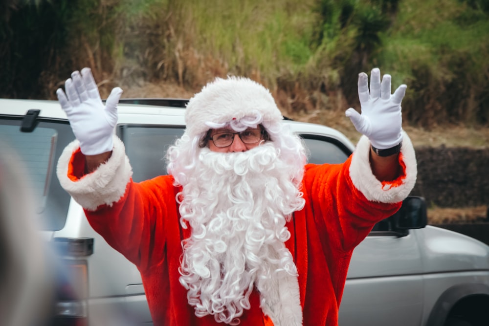 a man dressed as santa claus waves to the crowd