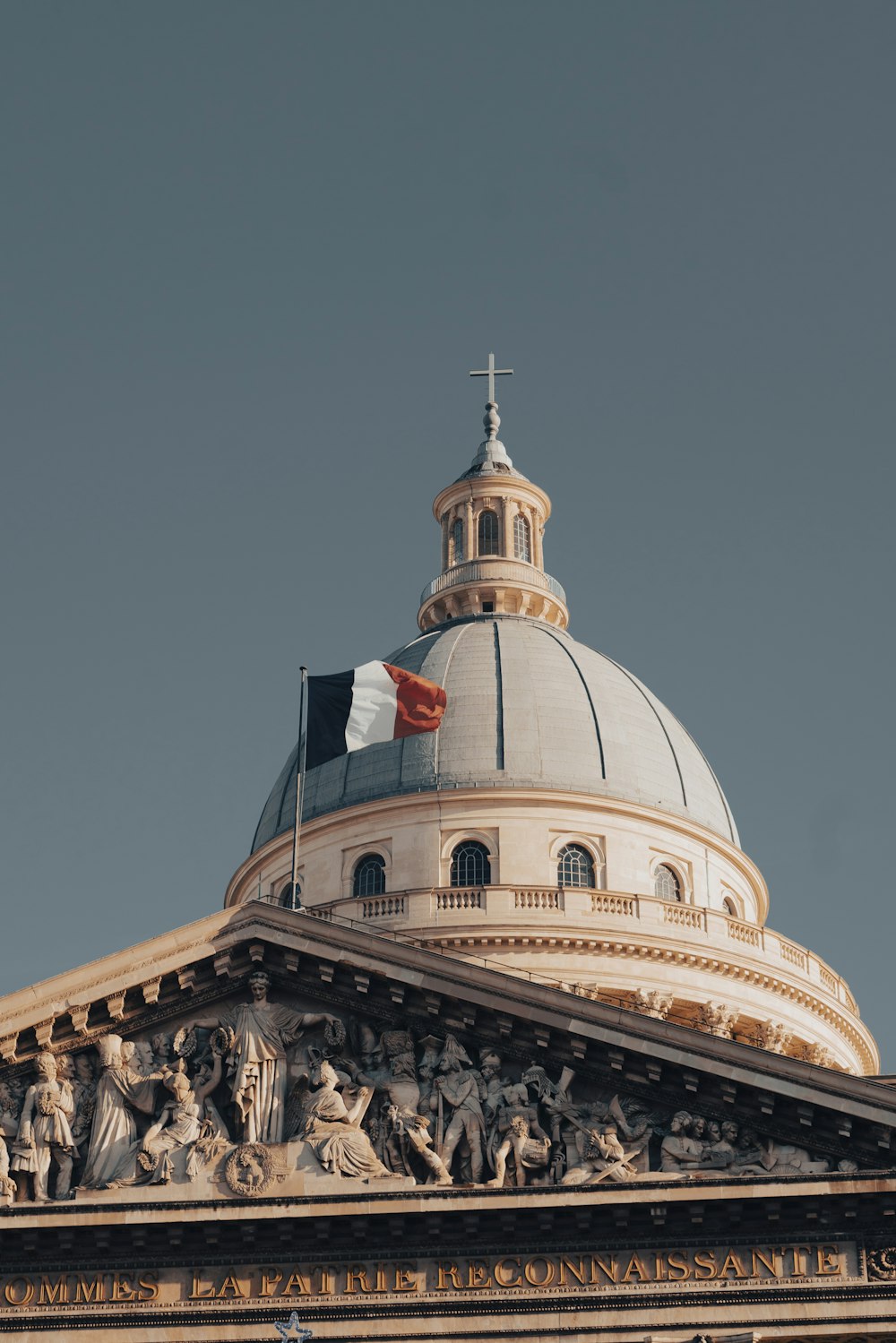 the dome of a building with statues on it