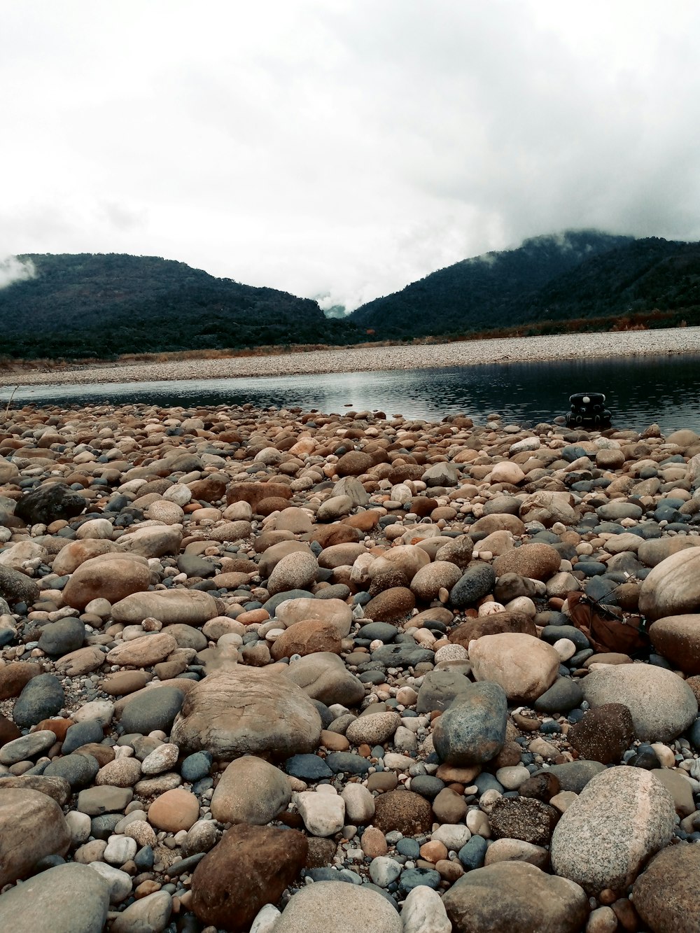 a rocky shore with a boat in the distance