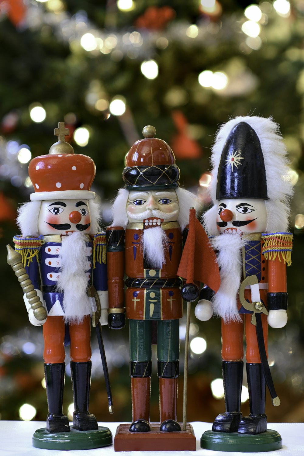 a group of nutcrackers standing next to a christmas tree