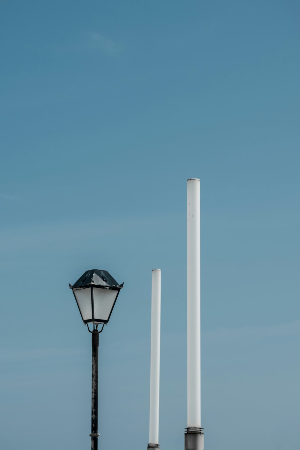 a street light sitting next to a white pole