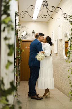 a bride and groom kissing in a hallway
