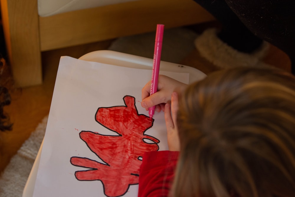 a child is drawing a picture with a pencil