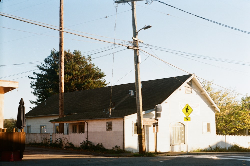 a white house with a yellow street sign in front of it