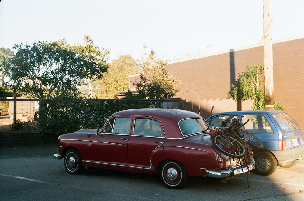 a red car parked next to a silver car in a parking lot