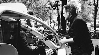 a black and white photo of a man talking to another man