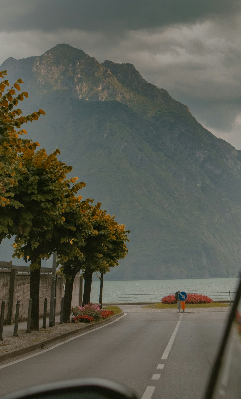 a car driving down a road with a mountain in the background