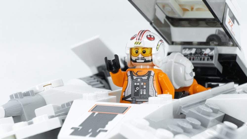 a lego man with a laptop on a white surface