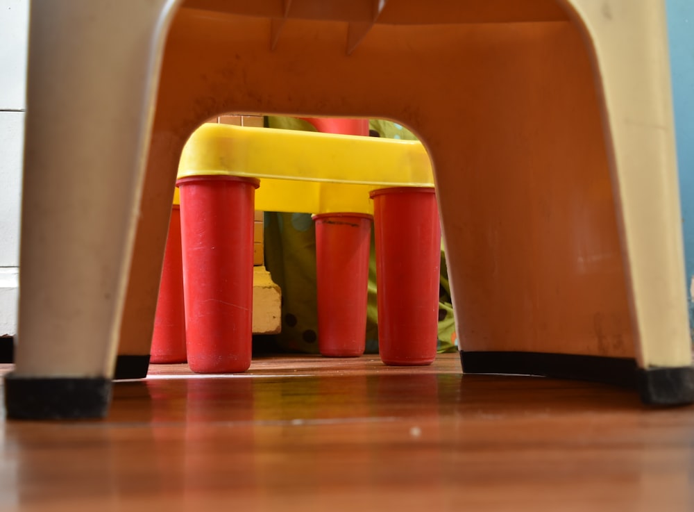 a child's chair with a yellow seat and red legs