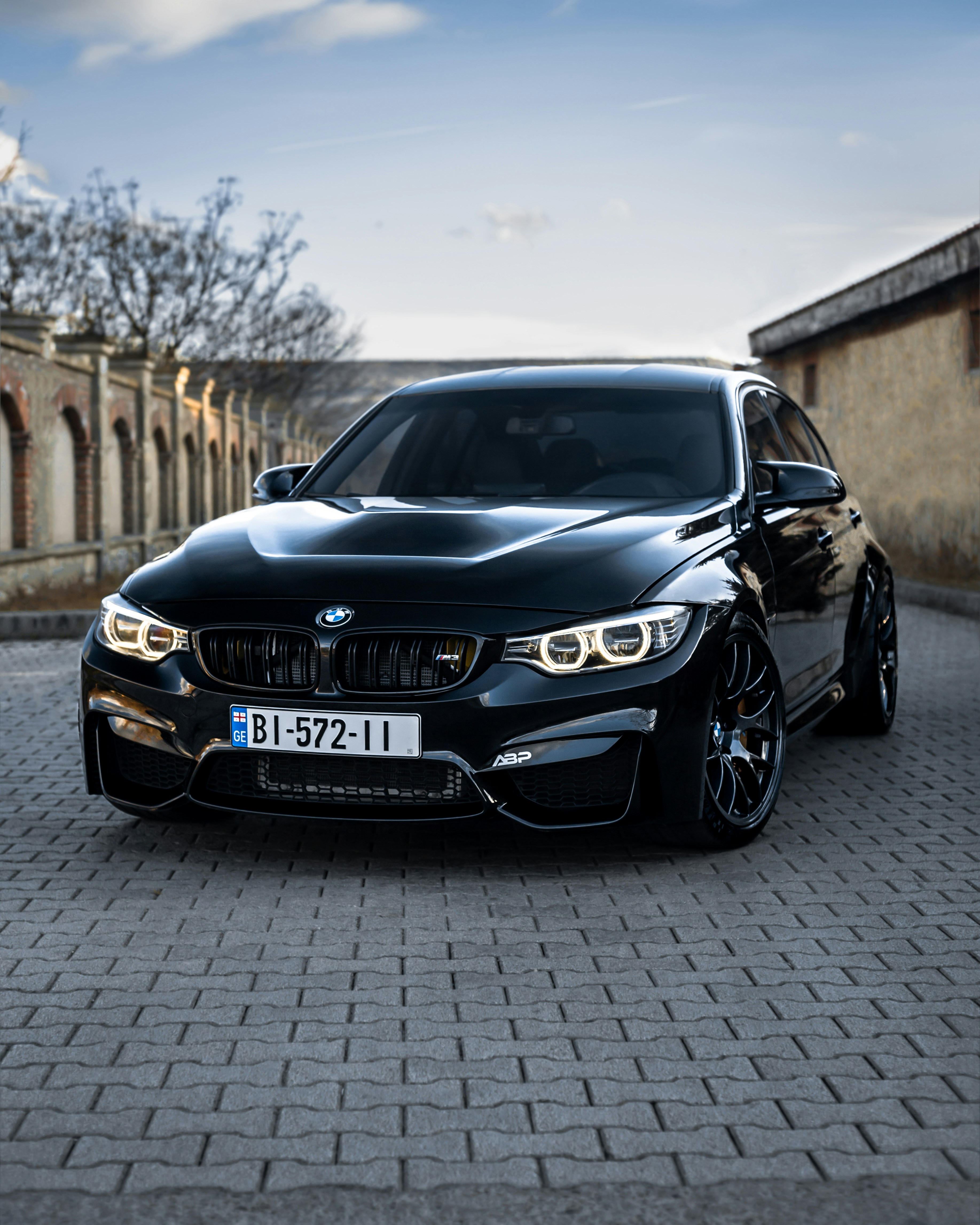 Ein schwarzes Auto, das auf einer Ziegelstraße geparkt ist
