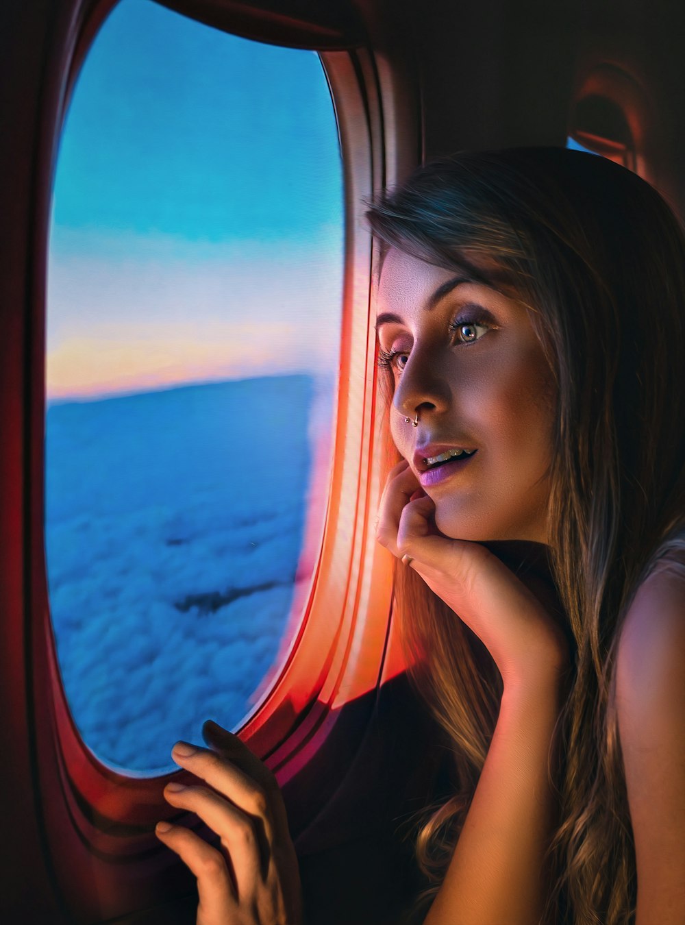 uma mulher olhando para fora de uma janela do avião