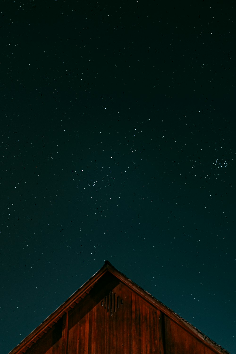 the night sky with stars above a barn