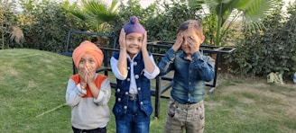 three children covering their faces with their hands