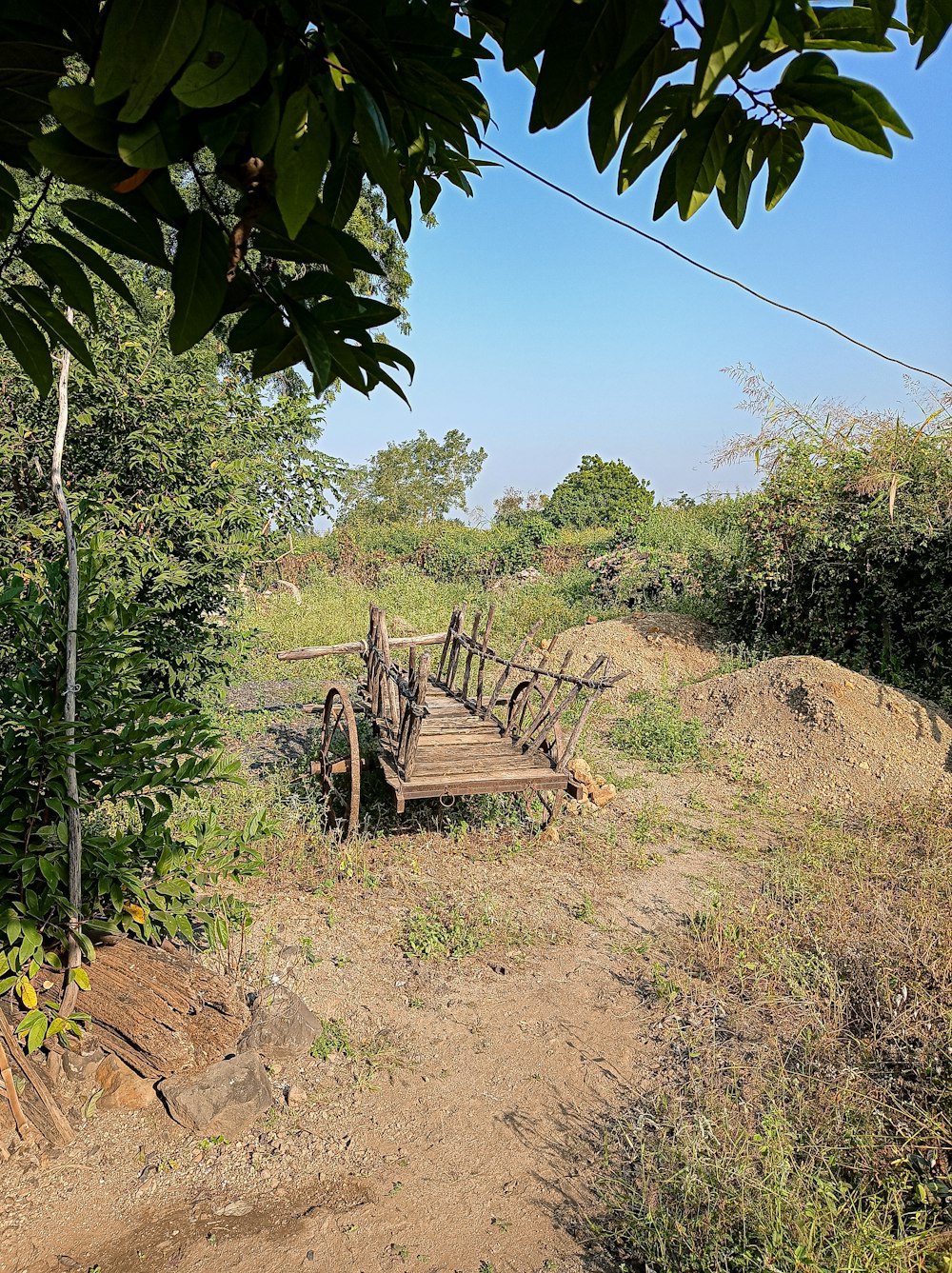 a wooden bridge in the middle of a field