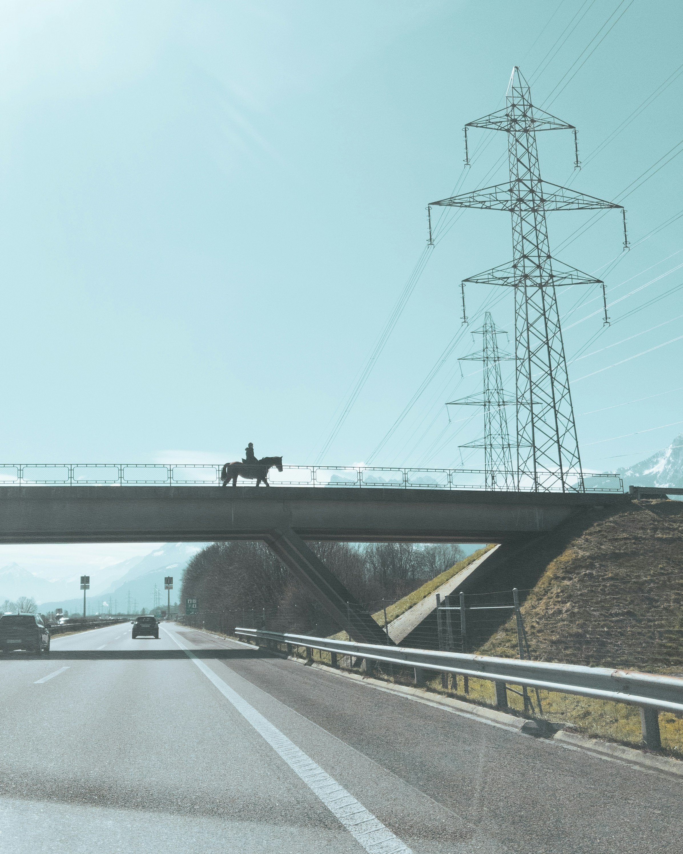 a person riding a horse across a bridge