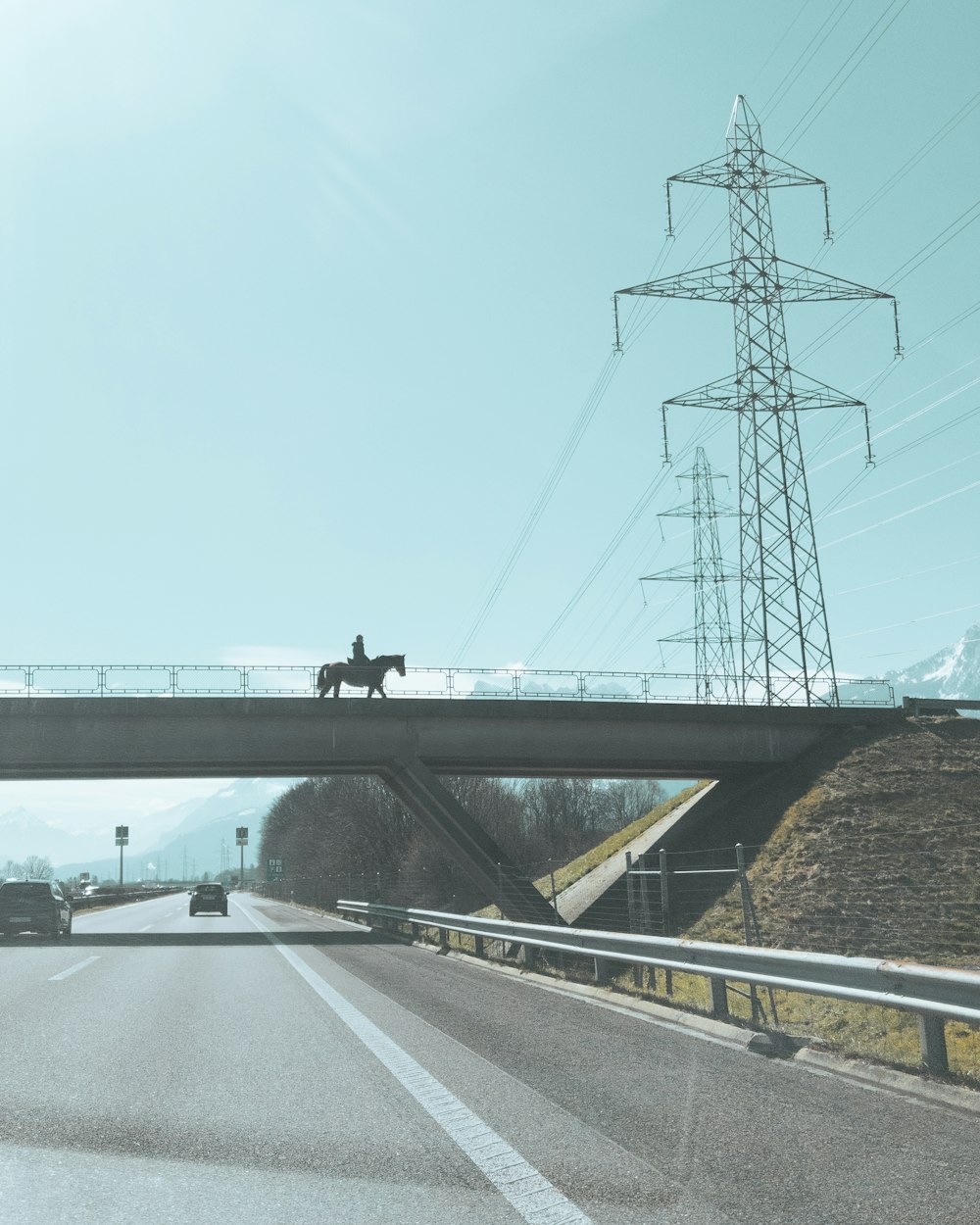 a person riding a horse across a bridge
