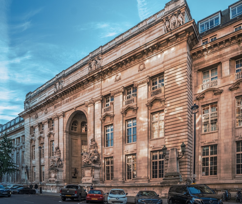 a large building with a lot of cars parked in front of it