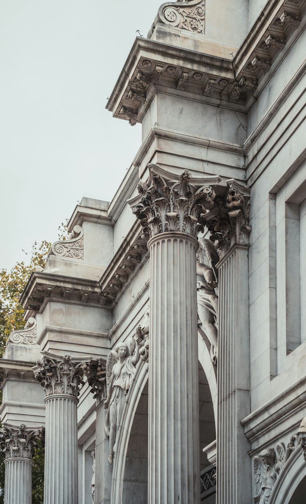 an old building with columns and statues on the front