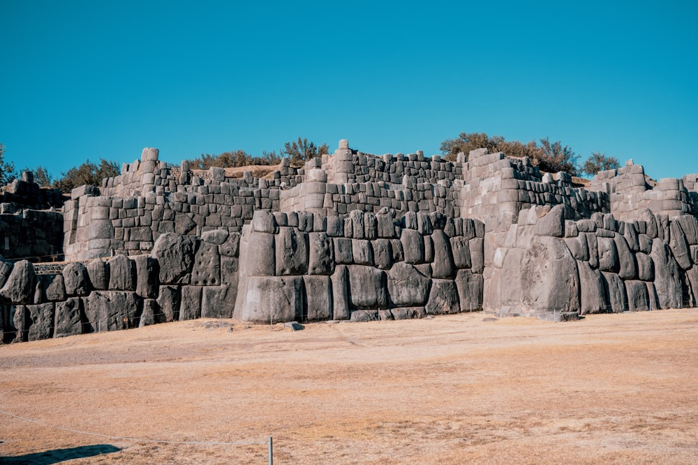 a large stone wall in the middle of a desert