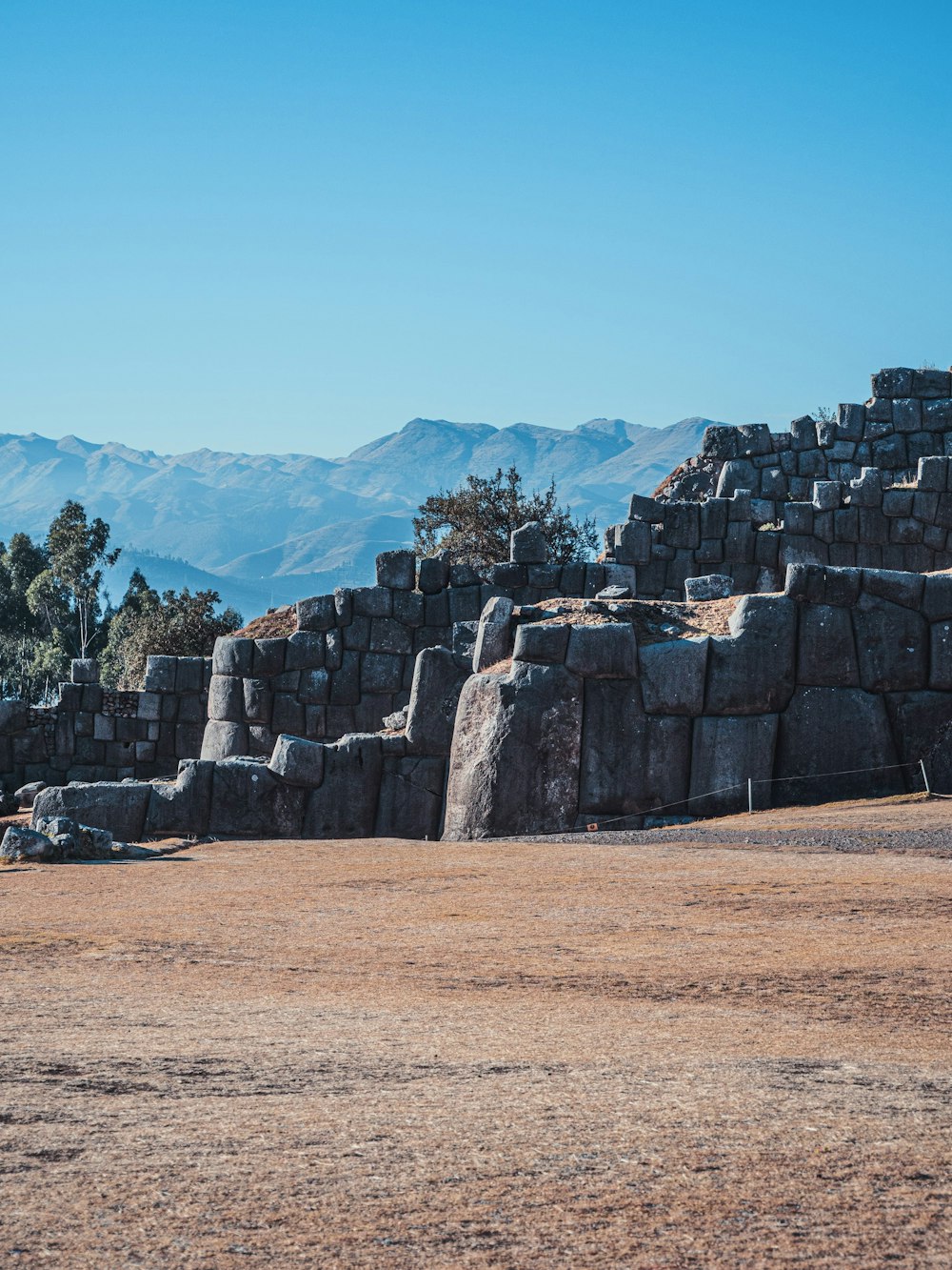 a large stone structure with mountains in the background