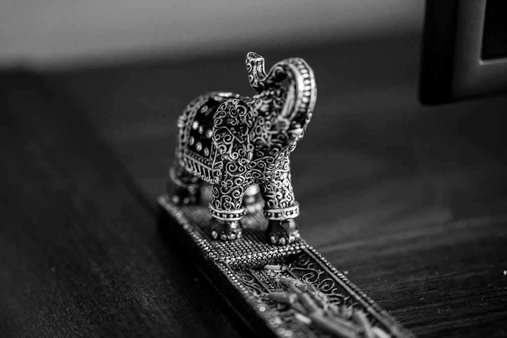 an elephant figurine sitting on top of a wooden table