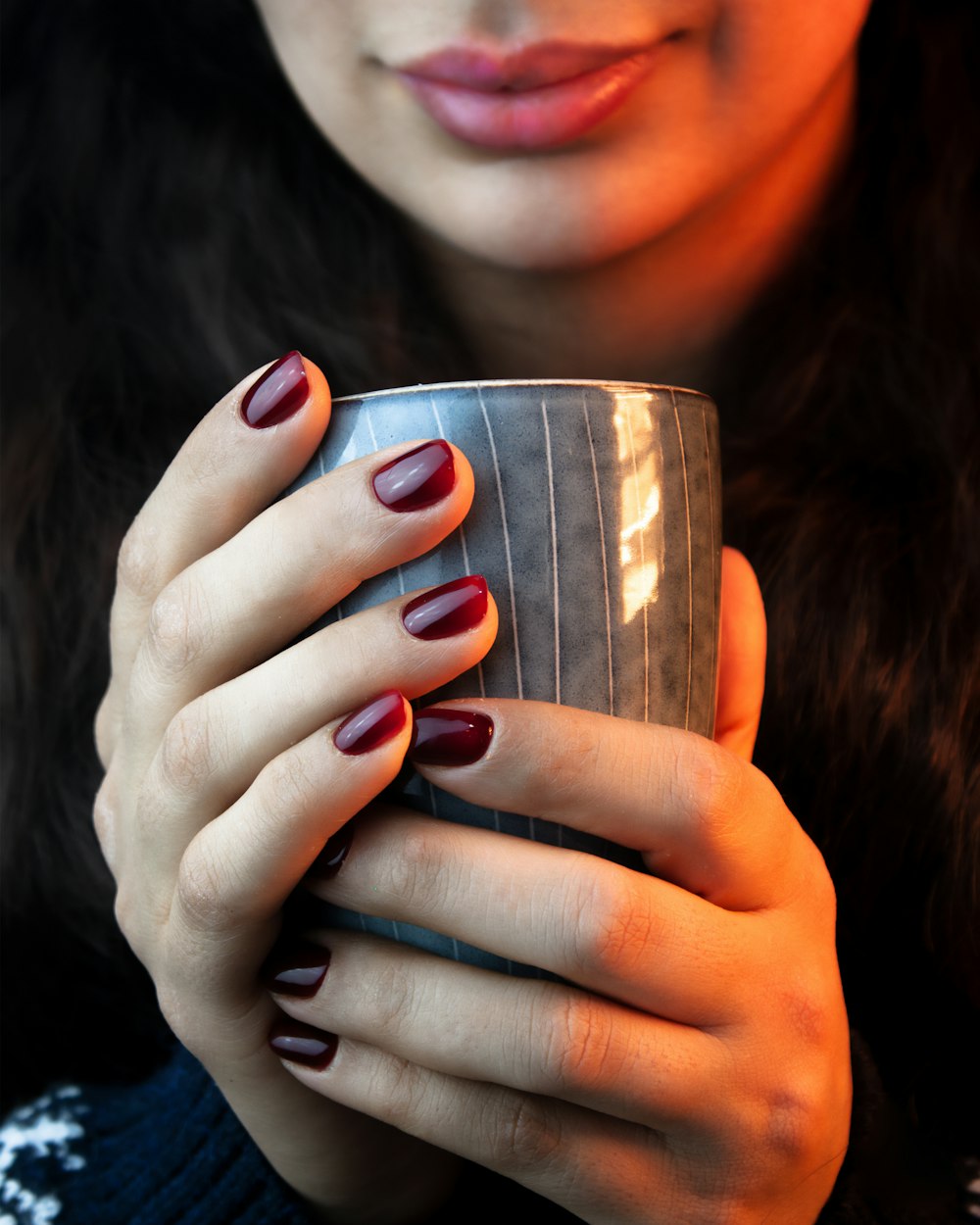 a woman holding a cup of coffee in her hands