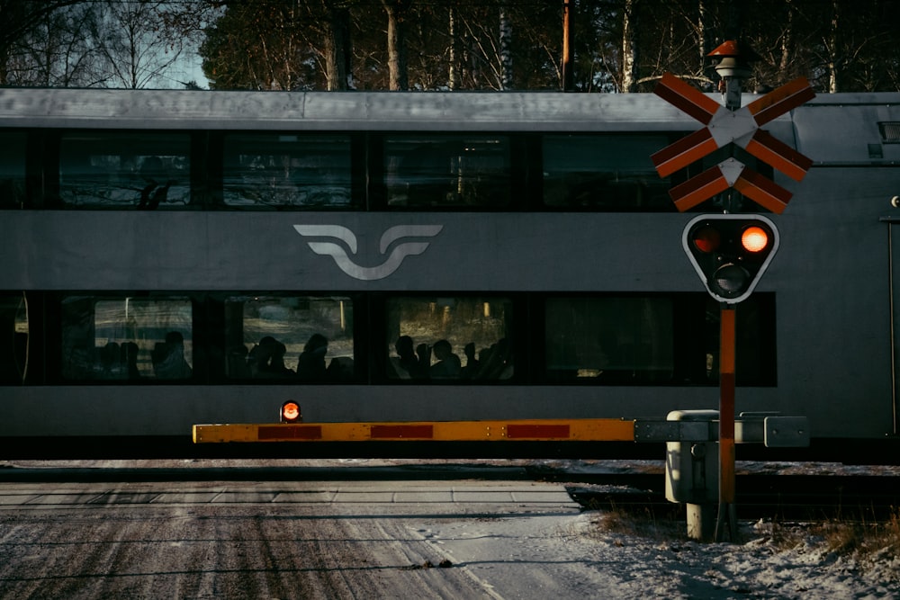 a train traveling past a train station next to a snow covered road