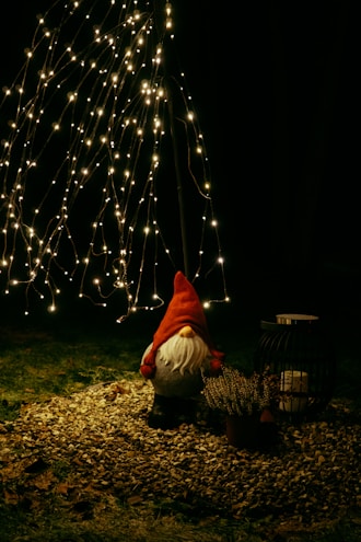 a person kneeling down next to a christmas tree