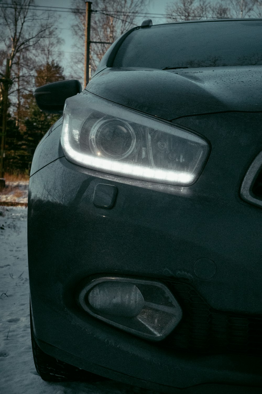 a close up of the front of a car in the snow