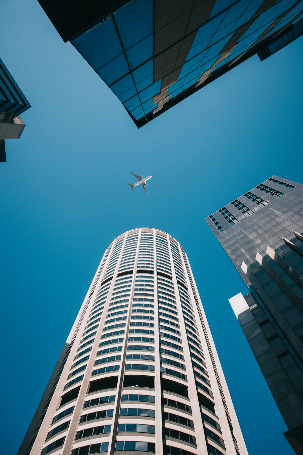 Ein Flugzeug fliegt am Himmel über einem hohen Gebäude