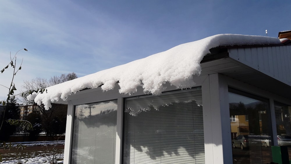a roof covered in snow next to a building