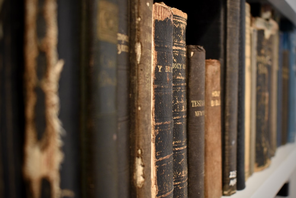 a row of books sitting on top of a white shelf