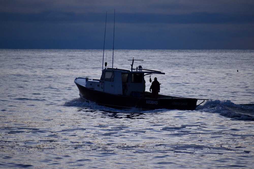 a boat with two people on it in the water