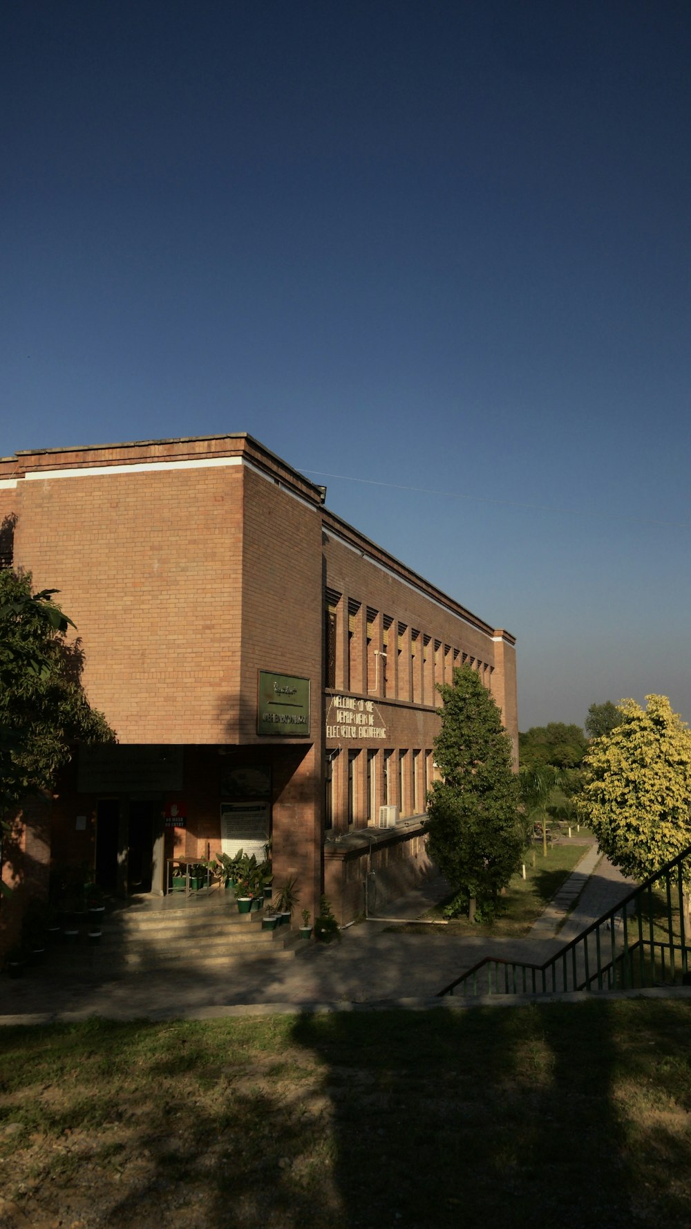 a large brick building sitting on top of a lush green field