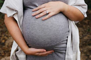 a pregnant woman holding her belly in her hands