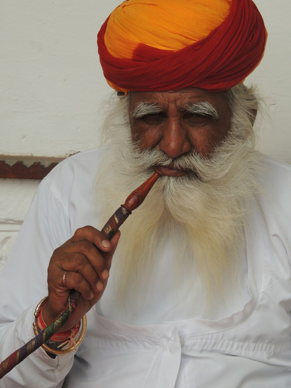 a man in a turban with a pipe in his mouth
