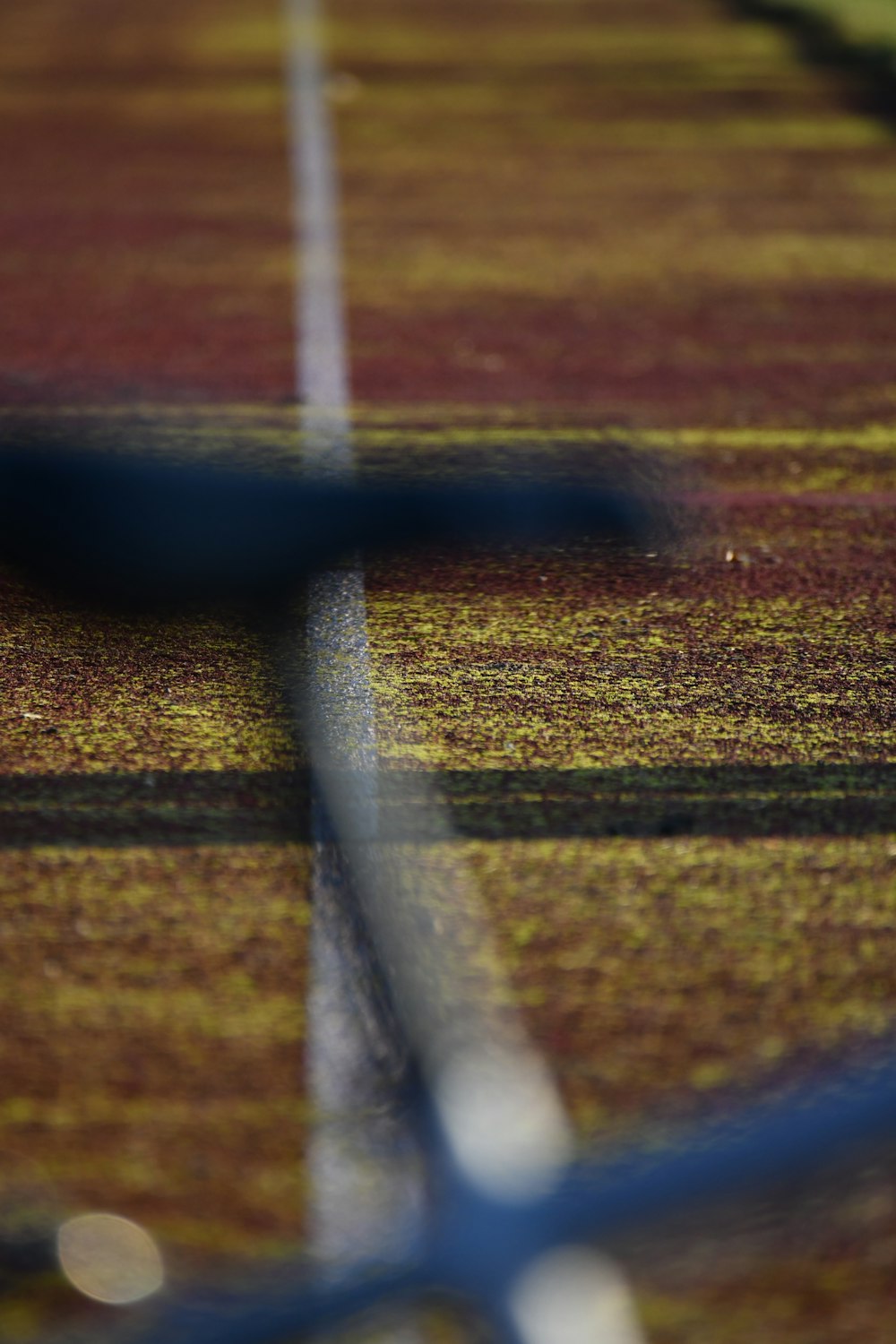 a tennis court with a tennis racket in the foreground