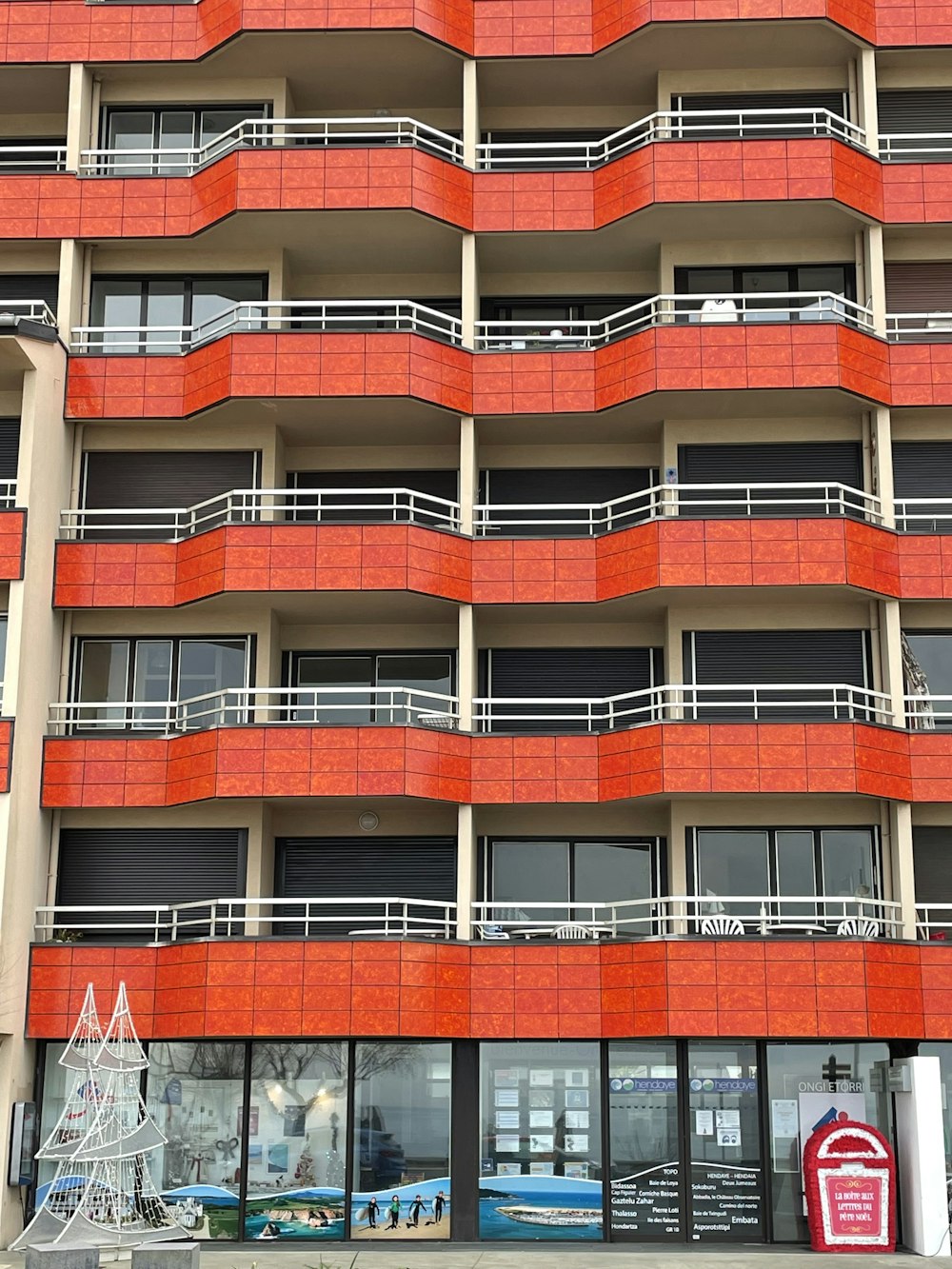 a tall orange building with balconies and balconies