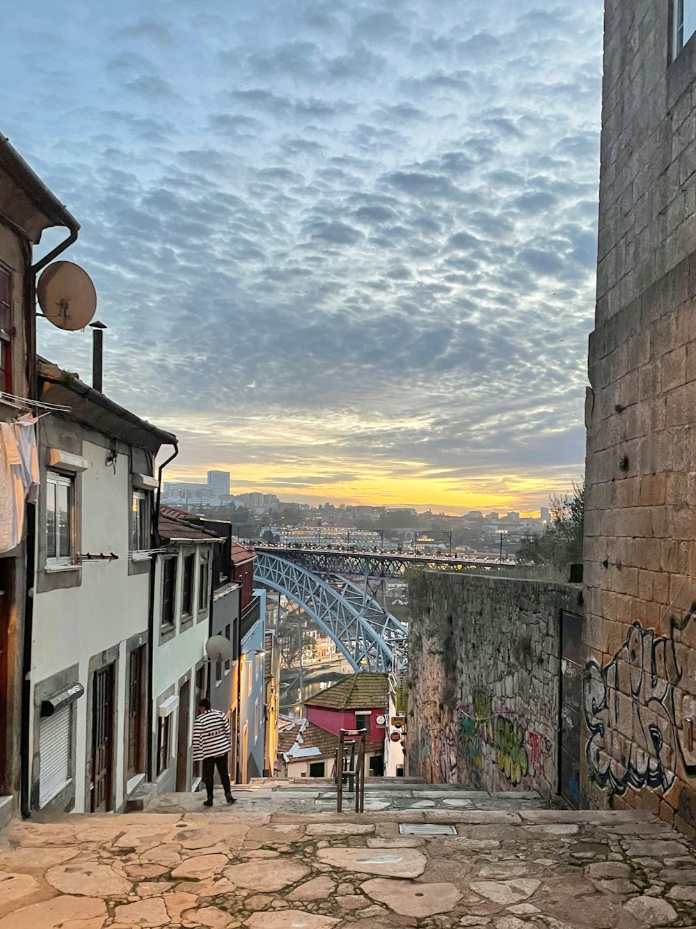 Un par de personas caminando por una calle al lado de edificios altos