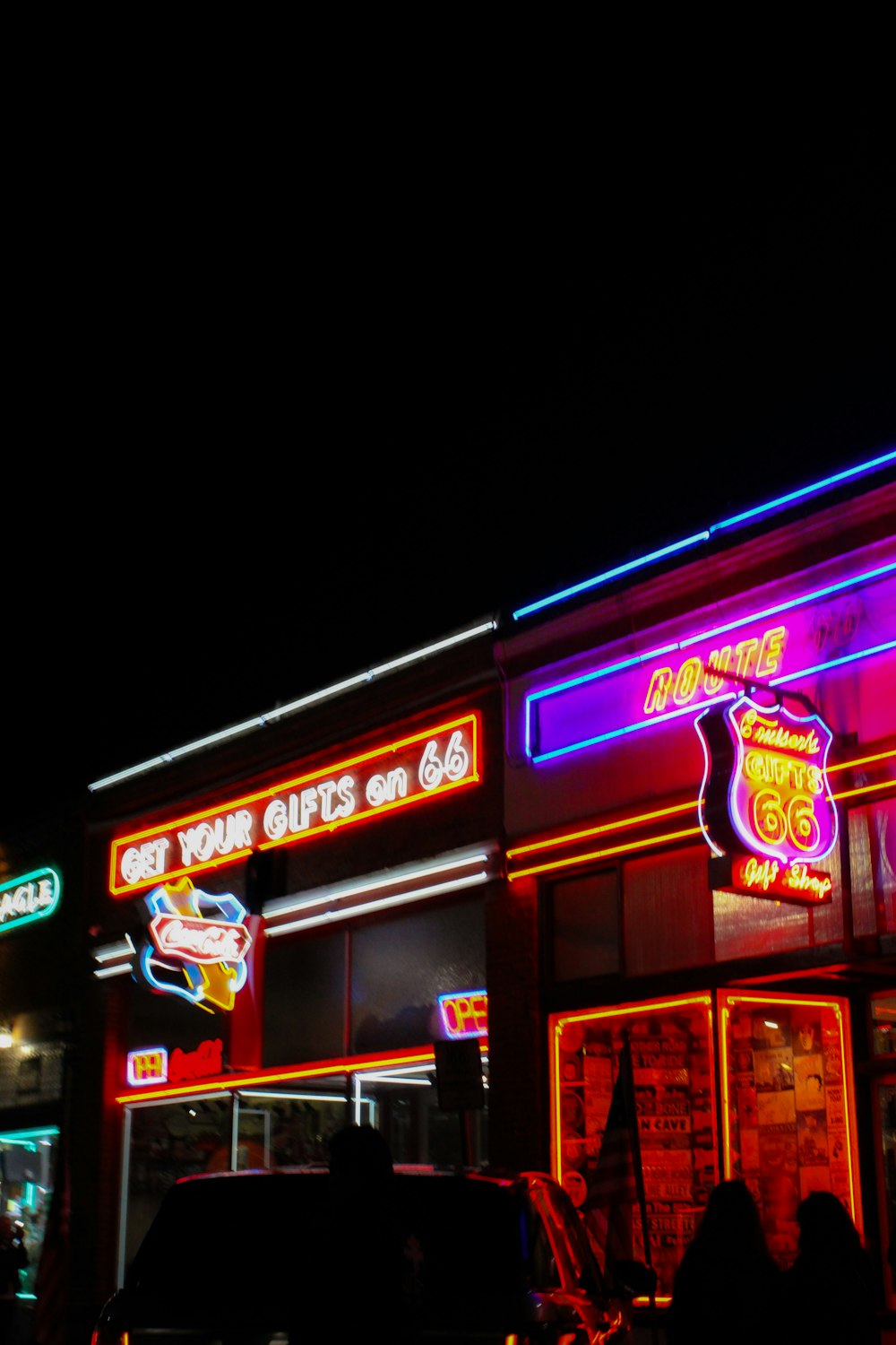 a building with neon lights and a car parked in front of it
