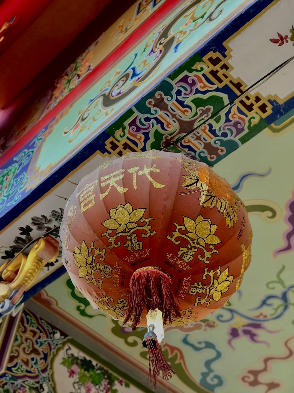 a chinese lantern hanging from the ceiling of a building