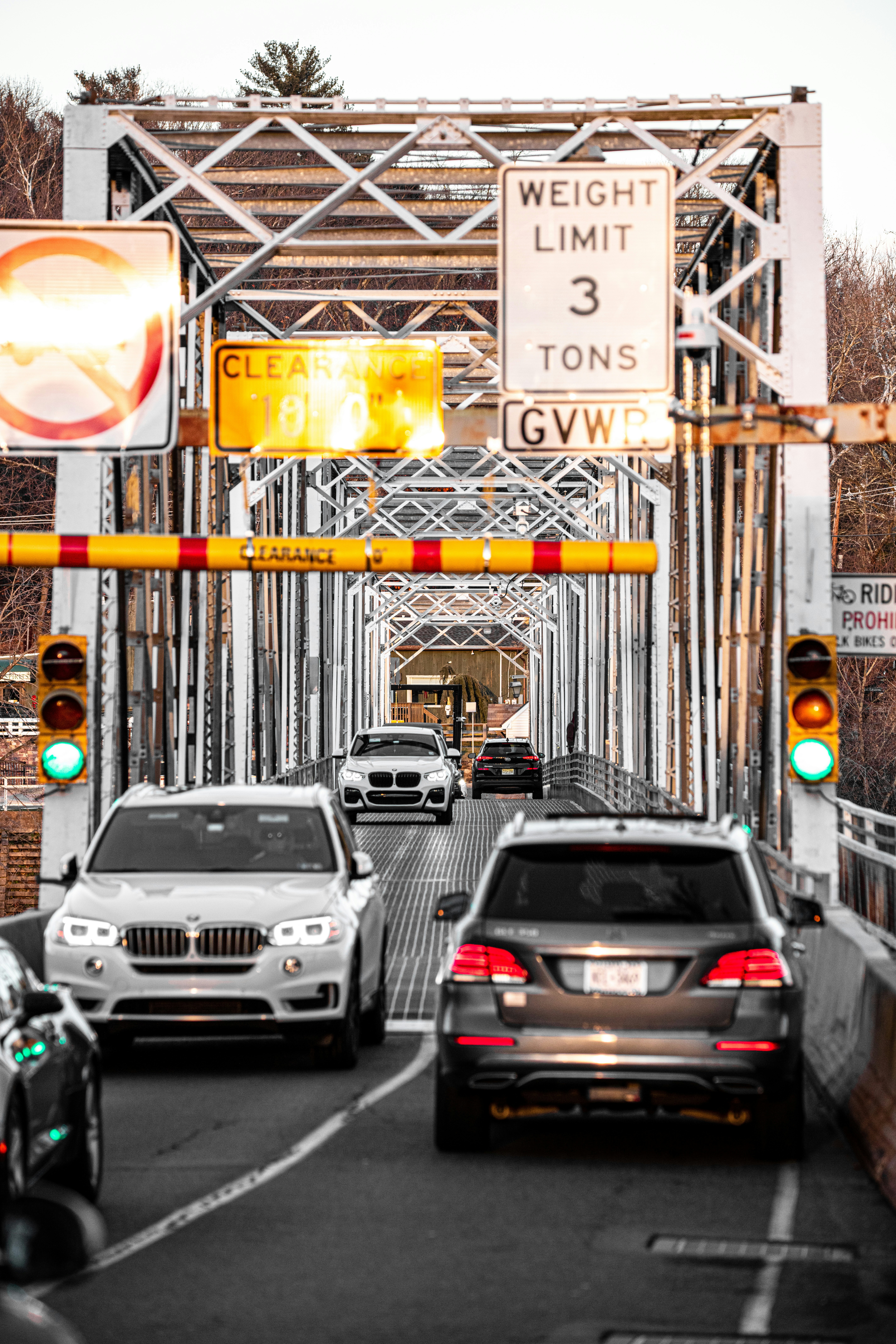 a group of cars driving down a street under a traffic light