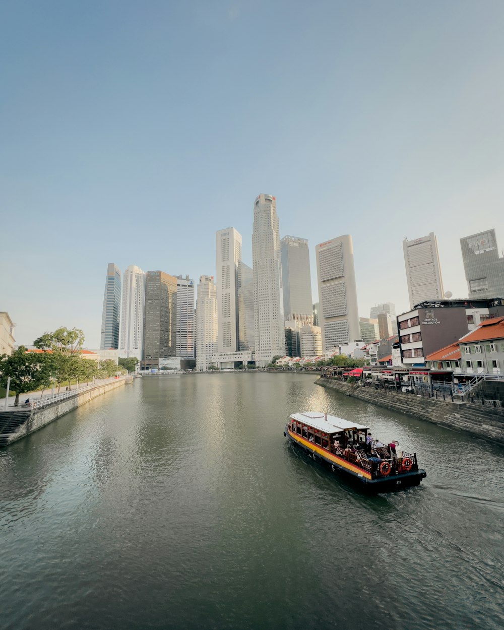 a boat traveling down a river next to tall buildings