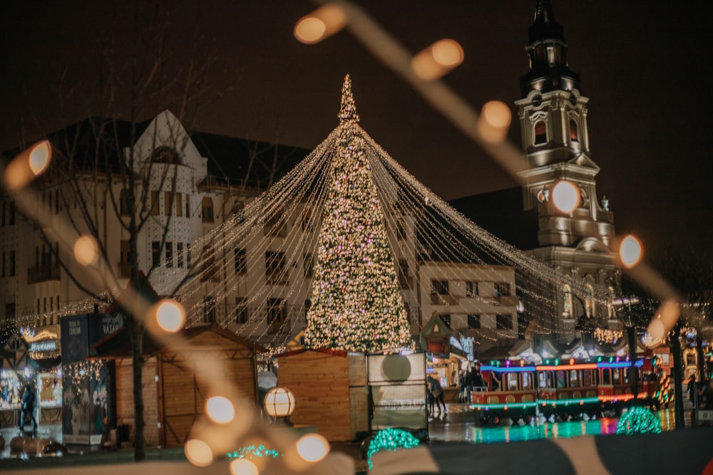 a christmas tree is lit up in front of a building