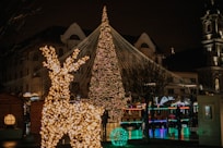 a lit up christmas tree in front of a building