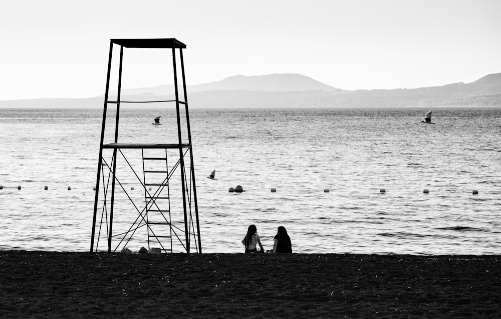 a lifeguard tower sitting on top of a beach next to the ocean