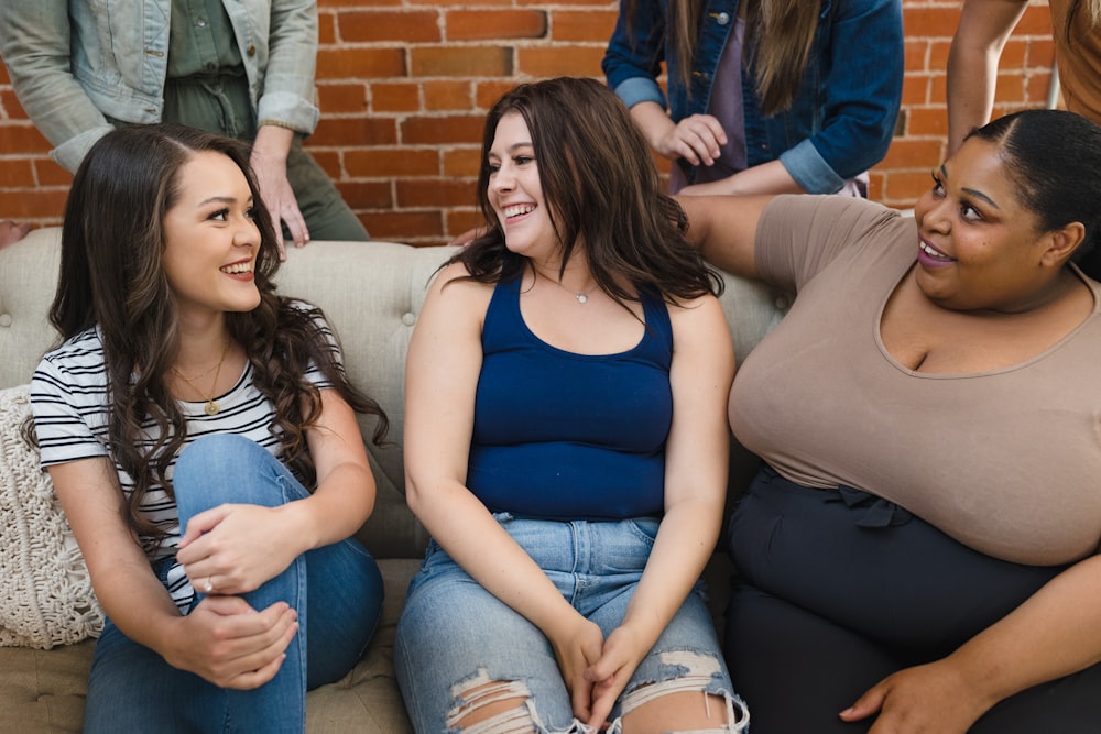 a group of women sitting on top of a couch